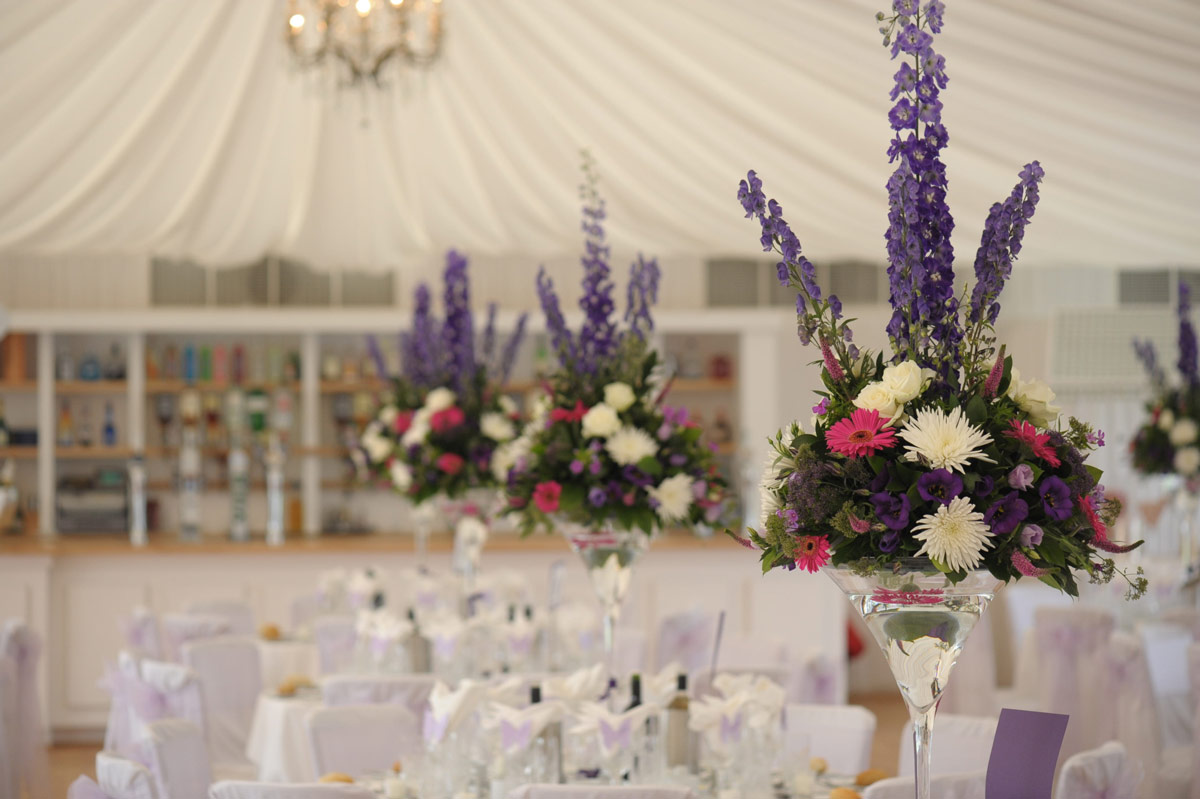 Close up view of wedding table decorations with purple flower bouquets
