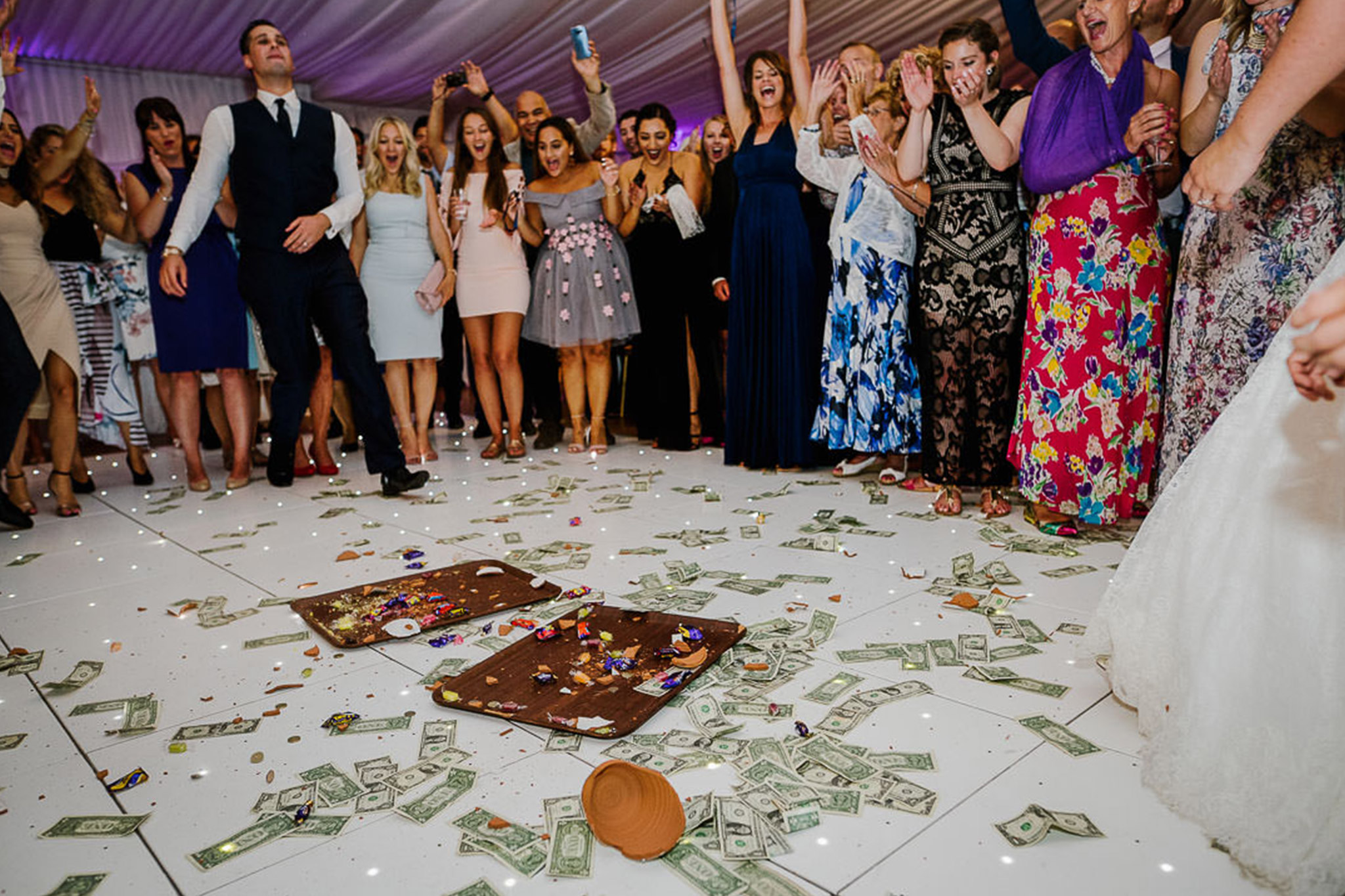 Turkish wedding party celebrating at Boreham house. With dollars and pots on the floor and bridal party cheering in the background