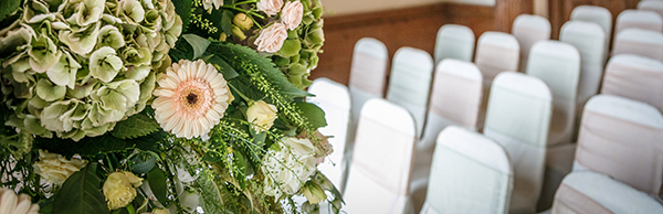 close up image of floral bouquet with covered chairs in the background