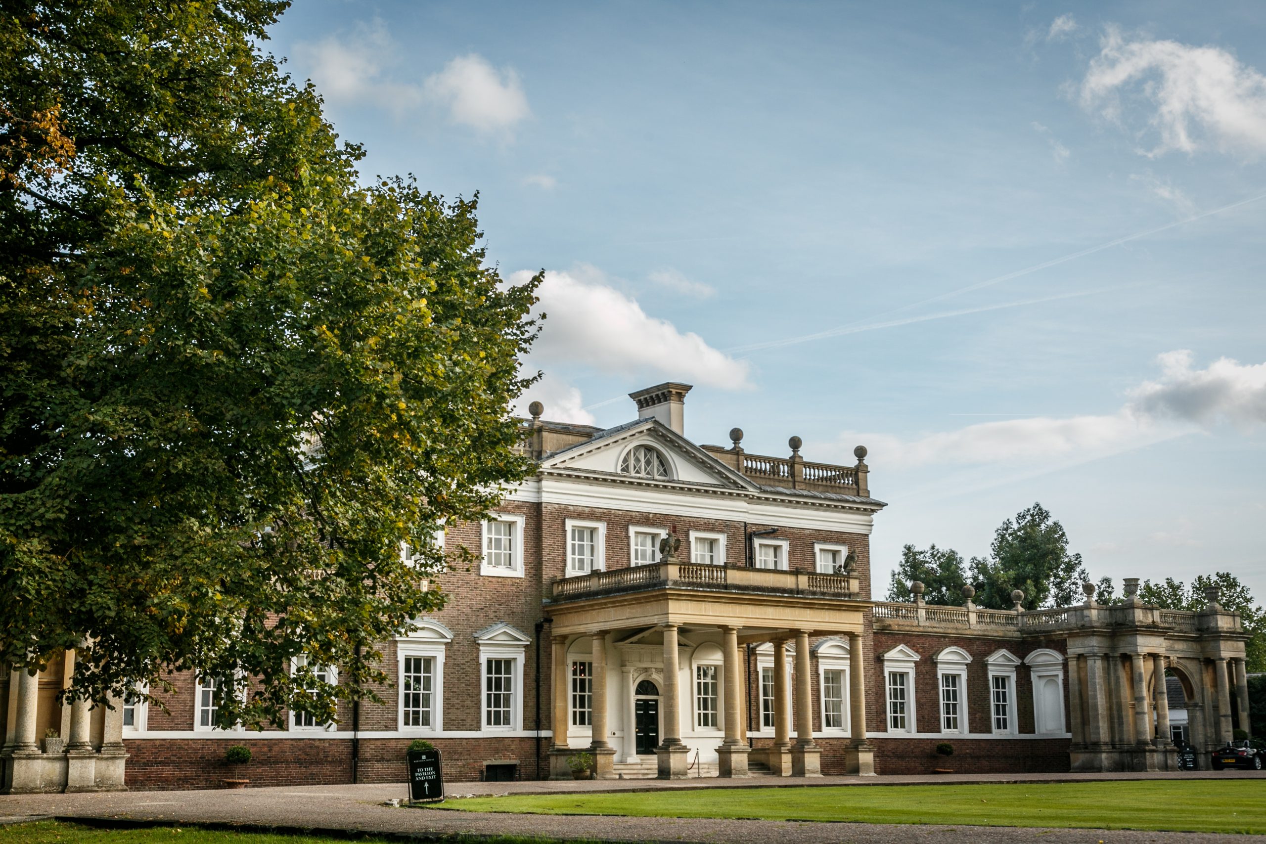 outside view of Boreham house wedding venue with green tree to the left and light blue sky