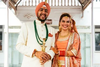 Sikh wedding couple smiling and holding hands