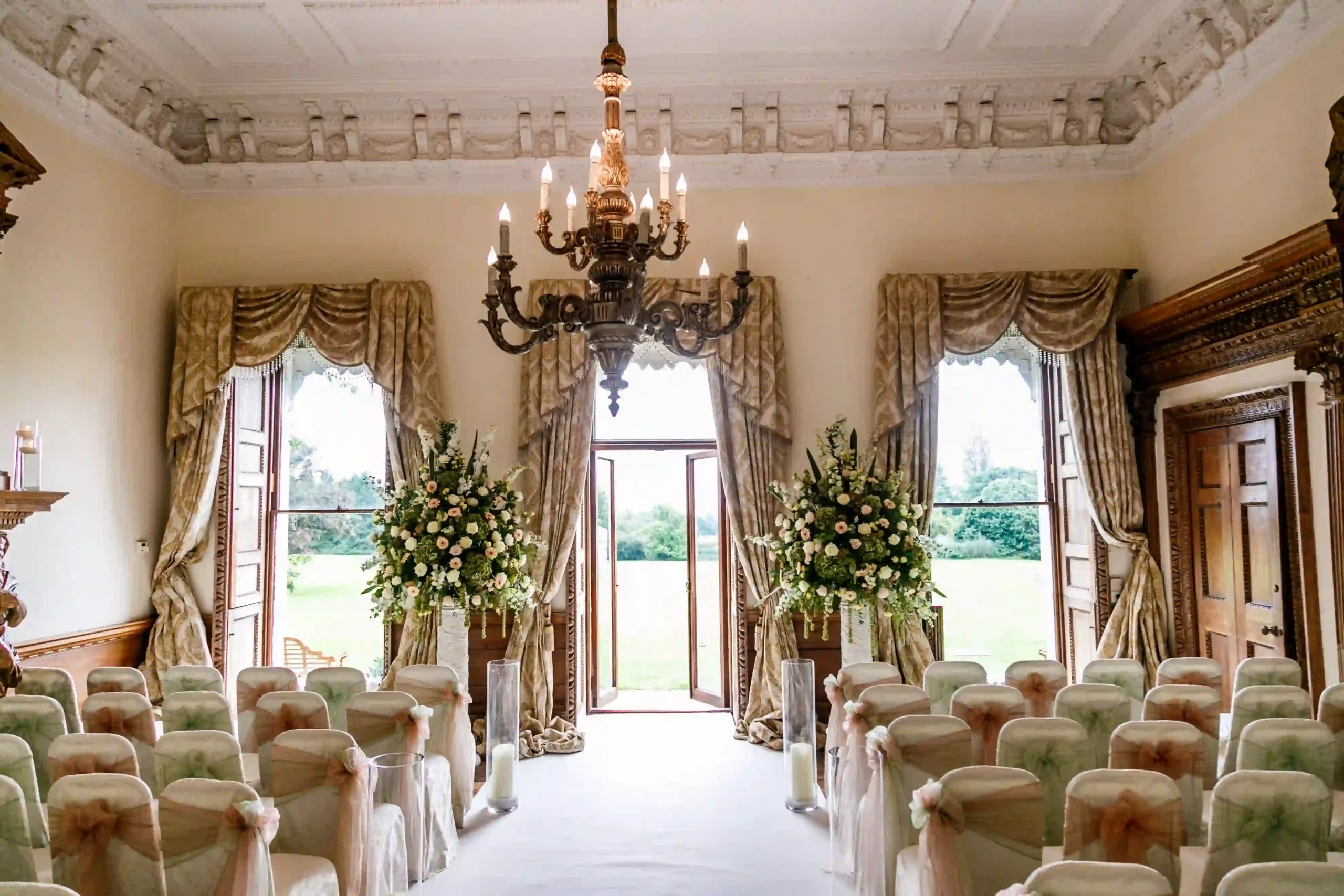 Ceremony venue at Boreham House with elegant chandelier in centre, and rows of dress chairs