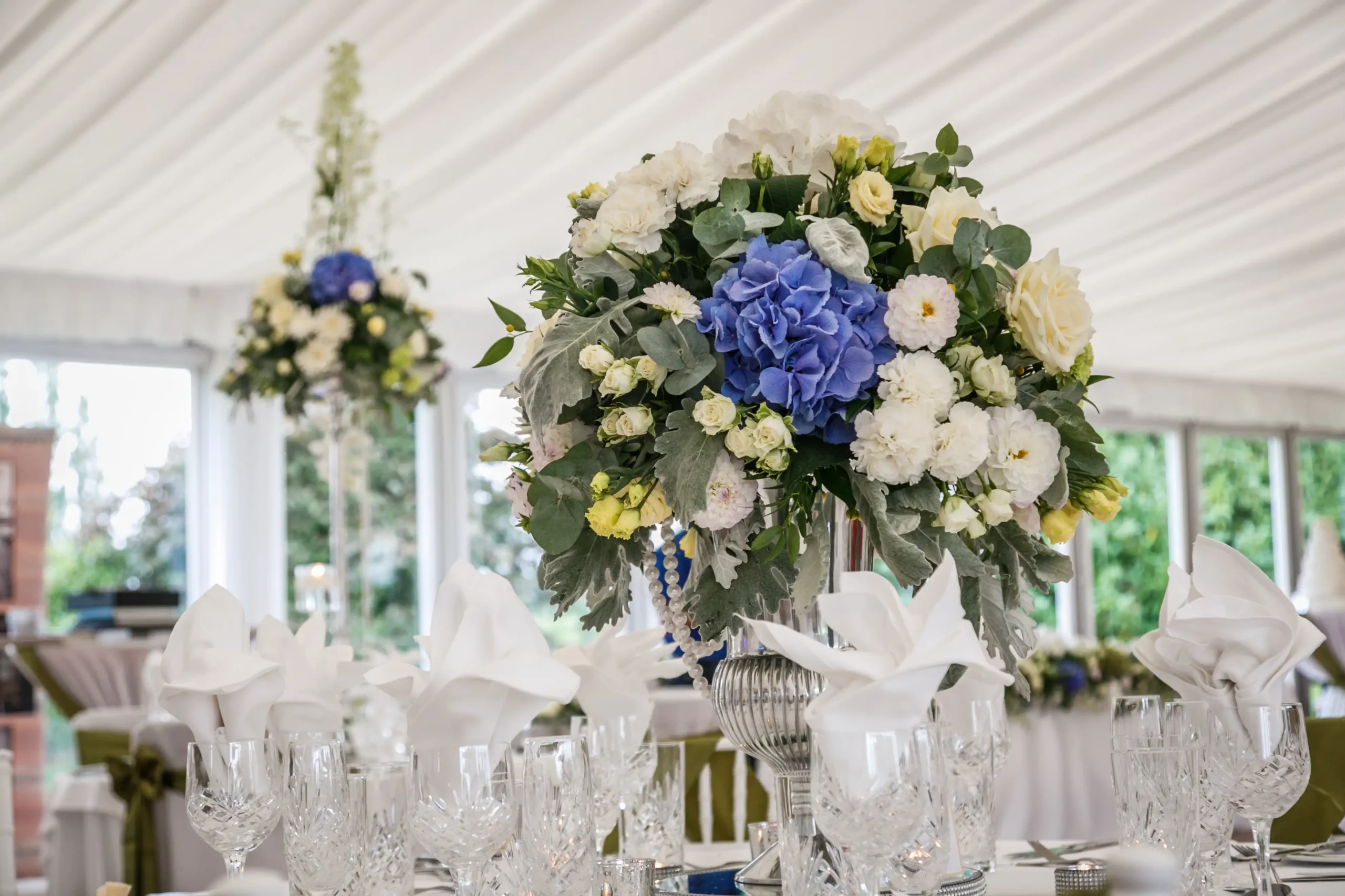 Reception room tables decorated with large centrepiece bouquet
